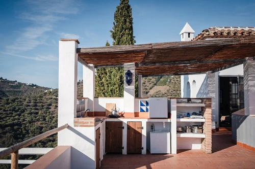 Summer dining in an outdoor Andalusian kitchen with stunning views on mountains and sea. Holiday house for outdoor sport trips around Andalusia
